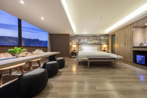 广州广州大道天河体育中心亚朵酒店的卧室配有一张床和一张桌子及椅子