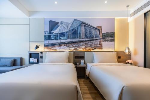 深圳深圳罗湖地王亚朵酒店的两张位于酒店客房的床,墙上挂着一幅画
