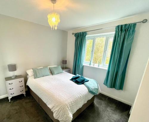 巴克斯顿Otterhole Barn Holiday Apartment的一间卧室设有床铺和一个带绿色窗帘的窗户。