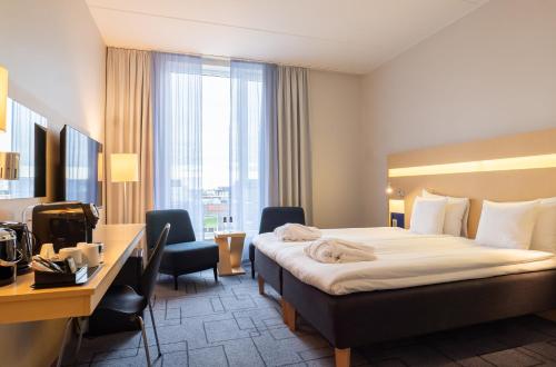 马尔默Best Western Plus Park City Malmö的配有一张床和一张书桌的酒店客房