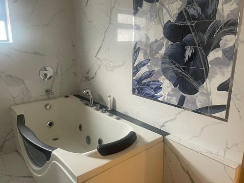 拉合尔Grey Orchard Homestay - A Family Place的带浴缸和镜子的浴室