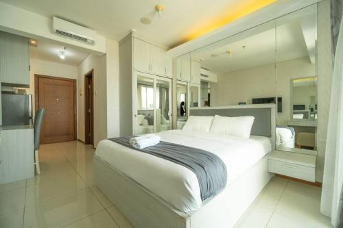 雅加达simple & stylish studio in central Jakarta, SCBD的一间带白色大床的卧室和一间厨房