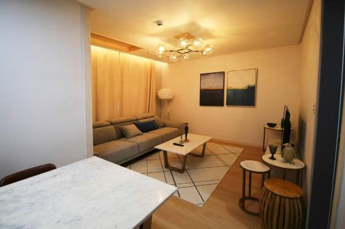 仁川市Firenze guest house - 10mins to Incheon international Airport的客厅配有沙发和桌子