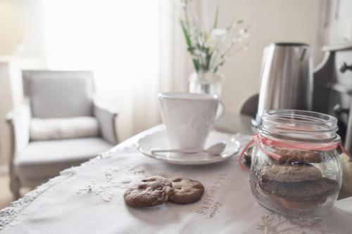 切塞纳蒂科Casina Le Conserve的一张桌子,上面放着一盘饼干和一杯咖啡