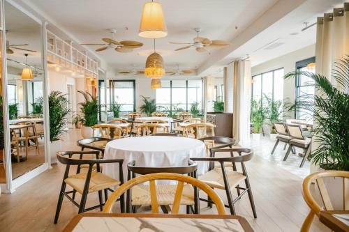 巴统The Grandeur Hotel的餐厅设有桌椅和窗户。