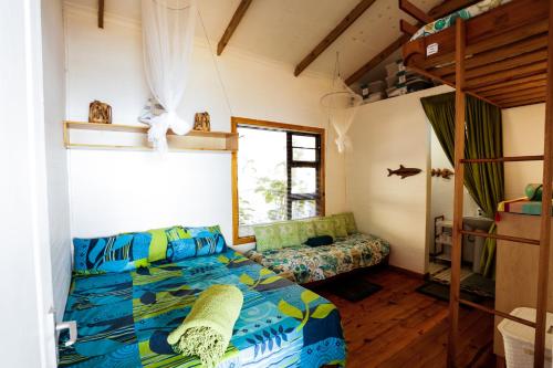 Ponta MalanganePequena Casa Holiday Home Malongane的一间卧室配有一张床和一张双层床。