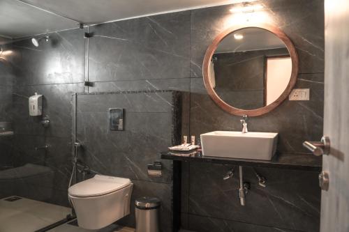 莫尔吉姆Ariena by Spree Hotels Goa的一间带卫生间、水槽和镜子的浴室