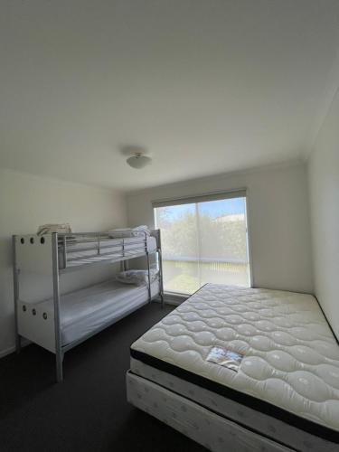 卡尔斯Cowes Holiday Home的一间卧室设有两张双层床和一扇窗户。
