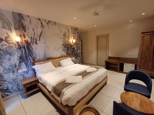 莫尔吉姆Ariena by Spree Hotels Goa的一间卧室配有一张大床和一把椅子