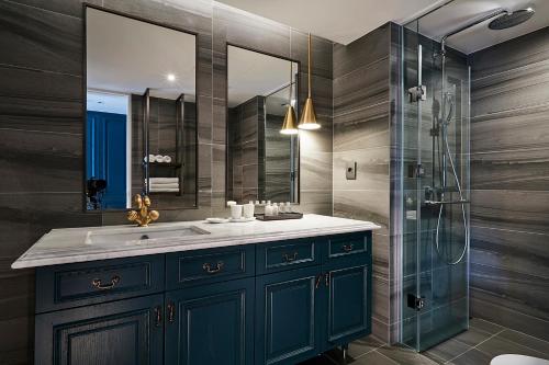 西归浦市套房酒店的浴室配有蓝色水槽和淋浴。