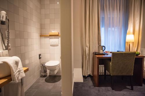 代尔登De Zwaan Delden的浴室配有卫生间、桌子和水槽。
