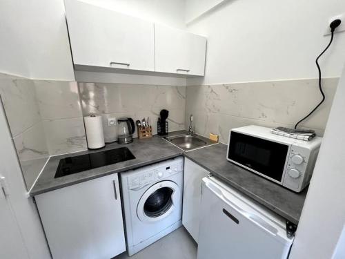 让蒂伊Studio cozy proche Paris的厨房配有洗衣机和微波炉。