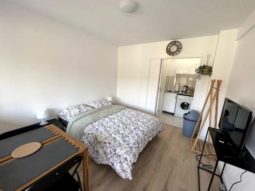 让蒂伊Studio cozy proche Paris的一间卧室配有一张床、一张桌子和一台电视。
