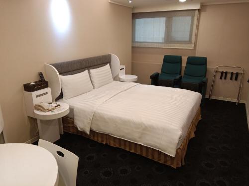 台北西門航棧商旅的一间医院间,配有一张床和两把椅子