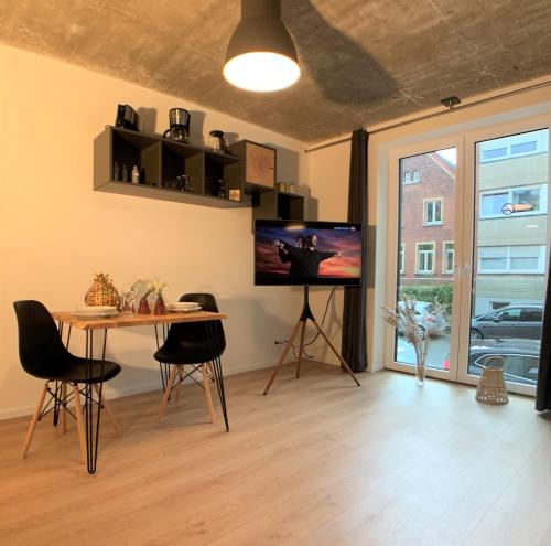 明斯特StadtHeimat29的客厅配有桌子和平面电视。
