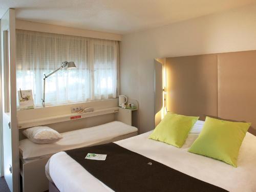 里永克莱蒙费朗～里永钟楼酒店的酒店客房设有两张床和窗户。