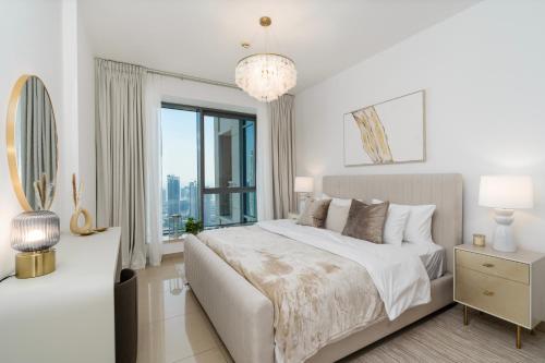 迪拜Prestige Living 2BR with Full Burj Khalifa and Fountain View by Auberge的白色的卧室设有一张大床和一个窗户