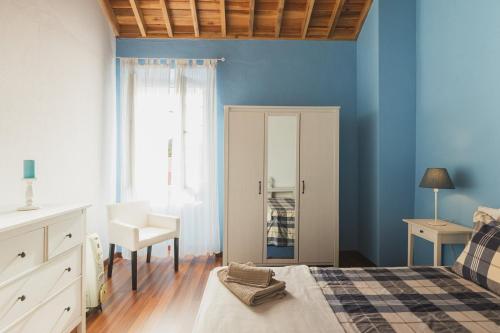 富尔纳斯WelcomeBuddy - O Moinho (Furnas Spring Water)的卧室拥有蓝色的墙壁,配有一张床和椅子