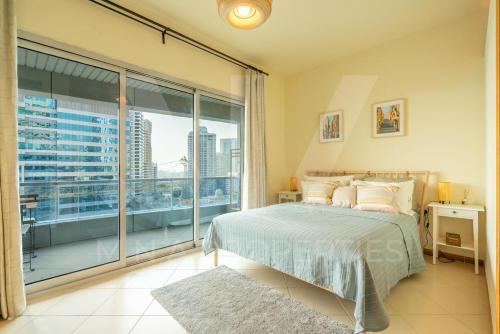 迪拜Apartment in Dubai Marina的一间卧室设有一张床和一个大窗户