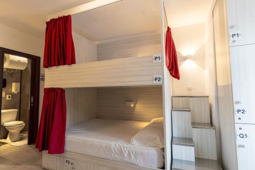 圣朱利安斯The Rose Hostel的一间卧室配有带红色窗帘的双层床