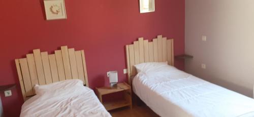 莫科斯吉拉博特Chalets à 10 minutes de Foix的红色墙壁客房的两张床