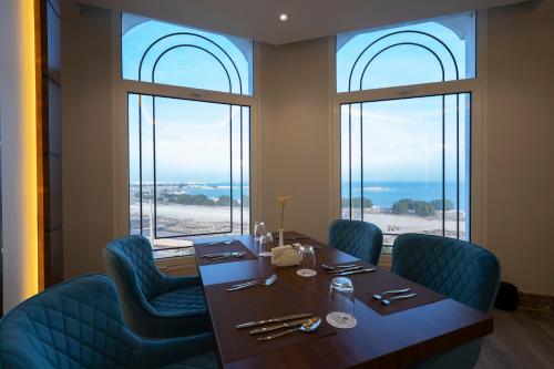 奥朱贝尔Braira Al Jubail的一间带桌椅和窗户的用餐室