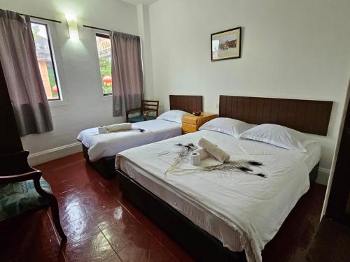 乔治市小印度传统别墅酒店的一间卧室设有两张床和窗户。