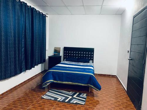 帕拉伊索Departamento en el centro, 2 recamaras, estacionam的一间卧室配有一张带蓝色毯子的床