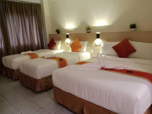 吉隆坡bintang hotel的一间酒店客房,房间内设有三张床