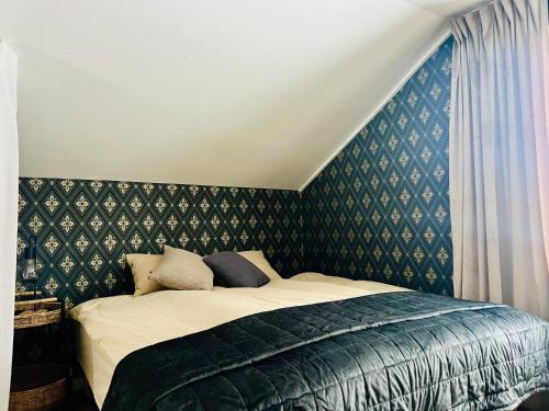 海勒福什Kaffestugan的一间卧室配有一张带绿色壁纸的床
