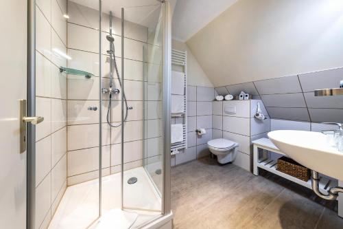 弗里斯特Hotel Leuchtfeuer的带淋浴、盥洗盆和卫生间的浴室