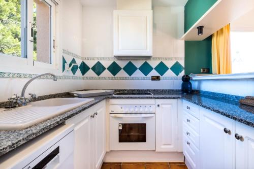 邦蒙特特雷斯诺维斯Fabuloso GESSAMI entre mar y montañas的厨房配有白色橱柜和蓝色及绿色的墙壁