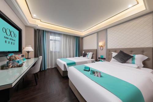 广州希岸酒店(广州江南西地铁站广百新一城店)的酒店客房设有两张床和一台平面电视。