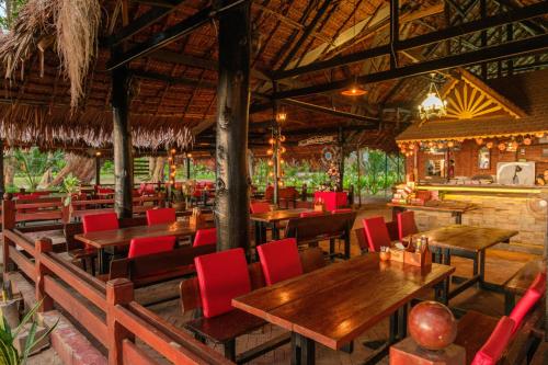 俊穆岛JOY简易别墅度假村&餐厅的餐厅设有木桌和红色椅子