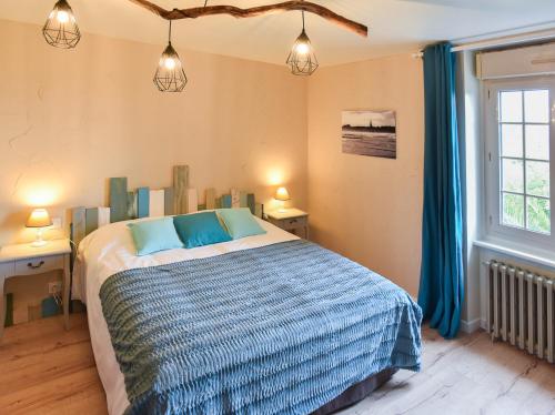康卡勒Petite Emeraude的一间卧室配有一张带蓝色枕头的床和一扇窗户。