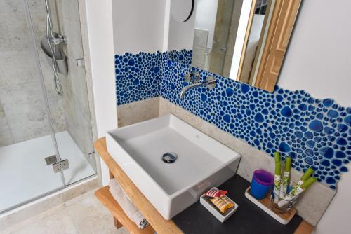 康卡勒Petite Emeraude的浴室配有水槽和蓝色及白色的瓷砖墙。