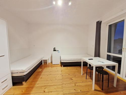 凯尔采Noclegi Kielce - Dom nad rzeką的客房设有两张床、一张桌子和一扇窗户。
