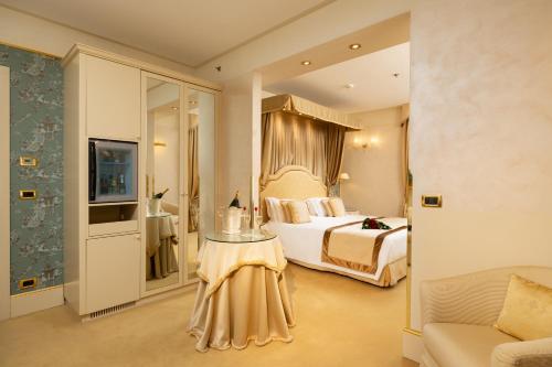 威尼斯亚拉克米狄亚酒店的一间卧室配有一张床、一张桌子和一张沙发