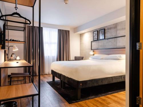 科尔雷恩ibis Coleraine Riverside的酒店客房设有一张大床和一张书桌。