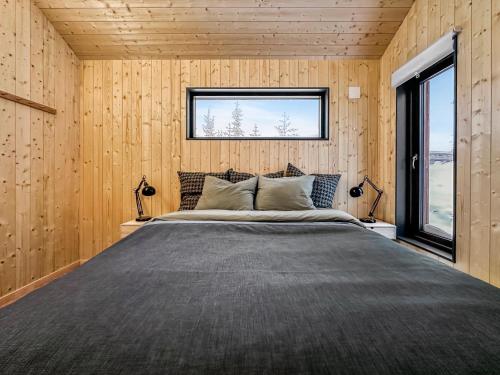 StrandeSki-in-out hytte på Kvitfjell的卧室配有一张木墙内的大床