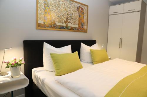 蒂索Haus Sterntaucher Ferienwohnung "Sonnenstern"的一间卧室配有带绿色和白色枕头的床