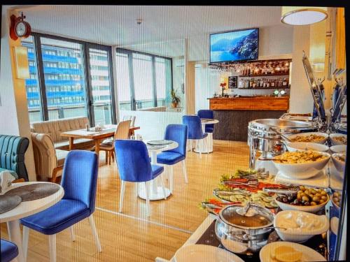 巴统Panorama Sea View Central City Batumi & ApartHOTEL的餐厅设有蓝色椅子,提供自助餐