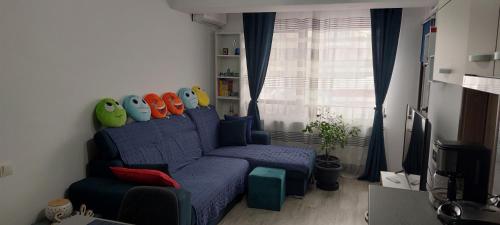 布加勒斯特LittleBIG Apartment的客厅配有蓝色沙发及色彩缤纷的枕头