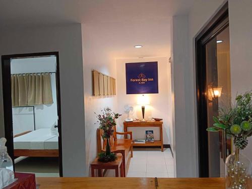 爱妮岛Forest Bay Inn El Nido的一间带桌子的客厅和一间卧室
