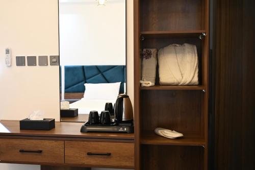 奈季兰SUN SET HOTEL فندق سن ست的配有电话和镜子的木制橱柜