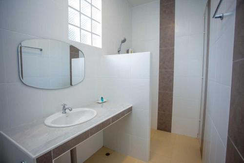 Amnat CharoenOYO 75464 Nakarin Hotel的白色的浴室设有水槽和镜子