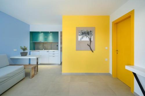 波托什Thassos OLIVIA RESORT的带沙发和黄色墙壁的客厅