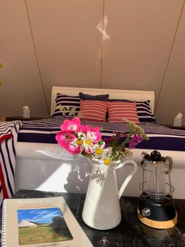 托波因特Tregantle Farm Eco GLAMPSITE的一间卧室配有一张床,一个花瓶摆放在桌子上