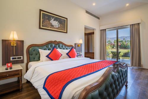 Thāna GhāziSpree Resort Sariska的一间带大床的卧室和一个阳台