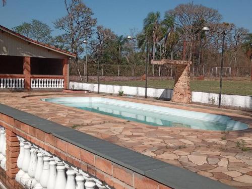 博图卡图casa c/4 dormitórios e piscina的一座带砖墙和砖的游泳池